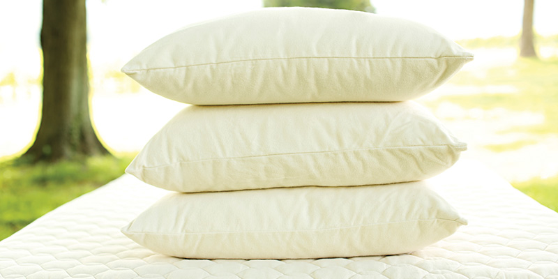 Pillows stacked on a mattress.