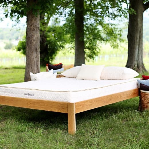 GOTS-certified organic mattress - Tranquility mattress on bed in outdoor setting with trees